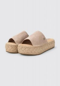 Zapatos slip-on de ante beige claro con una suela de plataforma de yute trenzado que presenta un diseño trenzado. Punta abierta y un estilo fácil y casual.