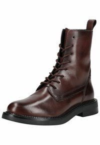 Tumma ruskea nahkainen nauhaliukupohjainen nilkkaboots, jossa on pyöreä kärki, kestävä musta kumipohja ja kontrastoivia saumoja sivussa.