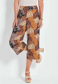 Culotte-stijl broeken met een patchworkpatroon in warme kleuren, met bloemen- en geometrische ontwerpen, gemaakt van lichte stof.