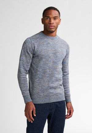 Grijs-blauwe gebreide sweater met een ronde hals, textuurpatroon en geribbelde manchetten. Draagt met donkerblauwe spijkerbroek. Eenvoudig, casual ontwerp.