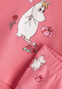 Ροζ φούτερ με παιδικούς χαρακτήρες κινουμένων σχεδίων, τριαντάφυλλα και δώρα. Απαλό ύφασμα με τυπωμένα σχέδια, που περιλαμβάνουν έναν λευκό χαρακτήρα και διακοσμητικά στοιχεία.