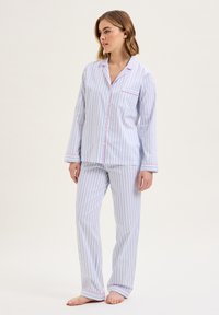 Set di pigiama a righe in blu chiaro e bianco, tessuto in cotone, maniche lunghe, camicia con bottoni e tasca, pantaloni abbinati a vestibilità ampia.