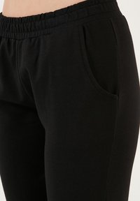 LELA Pantaloni de trening - black