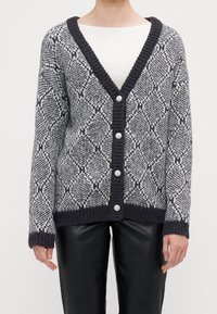Cardigan lavorato a maglia in nero e grigio con motivo a diamante. Presenta uno scollo a V, polsini a coste e sei bottoni rotondi e trasparenti.