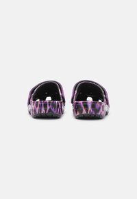 Black and purple patterned clogs with a glossy finish, featuring a back strap and textured sole for grip and durability.