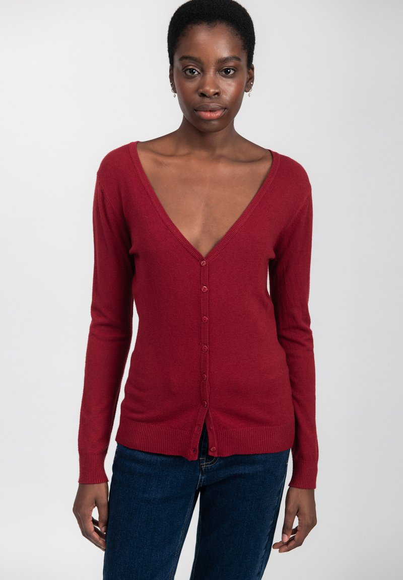 Cardigan bordeaux a collo a V realizzato in tessuto morbido, con chiusura a bottoni, maniche lunghe e polsini e orlo a coste.