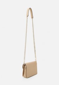 Beige crossbody taske med en tekstureret overflade, guldfarvet kædrem og en elegant rektangulær form. Lynlåsfag på siden.