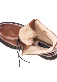 Bota de cuero marrón con forro interior suave, puntera redonda, suela plana y cordones. Presenta una textura contrastante en la zona del cuello y la lengua.