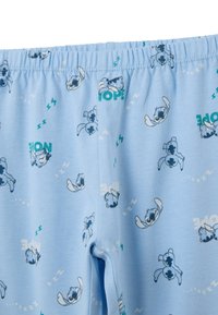 Lichtblauwe katoenen pyjamabroek met een elastische tailleband, met een print van cartoonhonden en de tekst "NEE" in groen en wit.