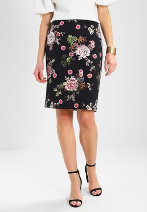 Jupe noire à fleurs avec un design ajusté, présentant des fleurs et des feuilles roses et vertes. Le tissu a une texture lisse ; l'ourlet arrive au niveau du genou.