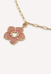 Gouden bloemenhanger ketting met roze edelstenen, met een holle kern en textuurpetalen, aan een gouden ketting met verlengde schakels.