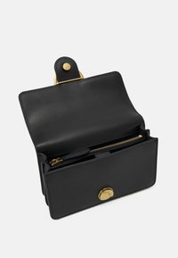 Portefeuille en cuir noir avec des accents dorés, présentant un design ouvert, un compartiment zippé et une fermeture à pression. Texture lisse, style minimaliste.