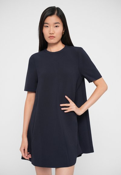 Navy short-sleeve dress with a round neckline and flared hem, made from smooth fabric. Notable features include minimalist design and side seam details.