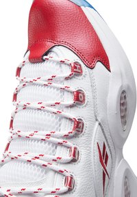 Weißer Ledersneaker mit roten Akzenten und transparenter Sohle. Verfügt über rot-weiße Schnürsenkel, Mesh-Einsätze und ein auffälliges Logo an der Seite.