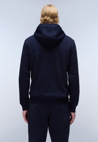 Sudadera con capucha azul marino con cordón, puños y dobladillo acanalados. La tela parece suave y ligeramente gruesa, diseñada para uso casual.