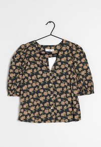 Blusa floreale scura con maniche corte a sbuffo, dotata di scollatura a V profonda e chiusura con bottoni. Motivo floreale in rosa e verde su sfondo blu navy.