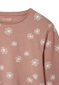 Staubrosa Langarmbluse mit rundem Halsausschnitt, geschmückt mit weißen Gänseblümchen-Mustern. Hergestellt aus weichem Baumwollstoff.