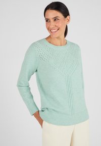 Maglione verde acqua con un design testurizzato sul davanti, scollo rotondo e polsini a coste. Realizzato in morbido tessuto lavorato a maglia.