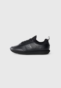 Zwarte leren sneaker met een ronde neus, textuuraccenten, vetersluiting en een logo dat aan de zijkant is gedrukt.