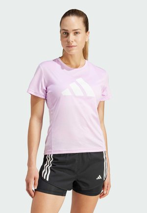 Camiseta atlética de manga corta en rosa claro con el logo blanco de Adidas, combinada con pantalones cortos negros que tienen rayas y logo blancos en el lateral.