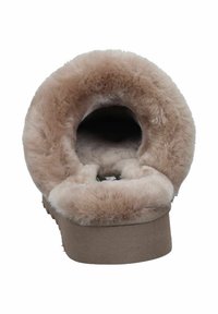 Fuzzy, beige slipper featuring a soft, plush lining, open back design, and a textured sole for traction.