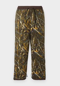 Camouflage trousers in a blend of green, brown, and blue hues. Features an elastic waistband, drawstring, and toggles at the ankle.