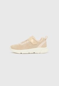 Beżowy lekki dzianinowy sneaker z białą podeszwą, elastycznymi sznurowadłami i paskiem na rzep na jednolitym tle.