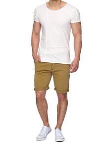 Biała koszulka z krótkim rękawem w połączeniu z khaki szortami, z podwiniętym dołem. Obuwie to białe trampki o klasycznym wzorze.