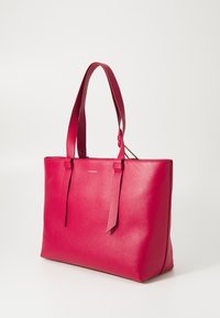 Bolsa tote de couro rosa com alças duplas, textura suave e design minimalista. Apresenta uma etiqueta lateral para identificação da marca.