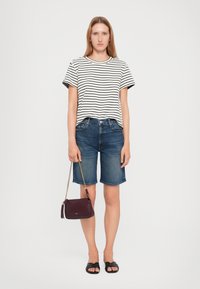 Striped short-sleeve t-shirt, blue denim shorts, black flat sandals, and a small burgundy crossbody bag with a chain strap.