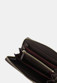 Portafoglio in pelle marrone con texture, dotato di zip dorata, che presenta diversi scomparti per carte e un compartimento centrale chiuso da zip per monete o piccoli oggetti.