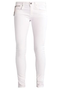 Vaqueros blancos ajustados de denim con una textura suave; bolsillo frontal con cremallera y herrajes metálicos, diseño simple y sin patrones visibles.