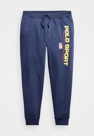 Pantalones de chándal de color navy en tela suave con cintura ajustable. Presentan tipografía amarilla que dice "POLO SPORT" y un pequeño acento con la bandera americana.