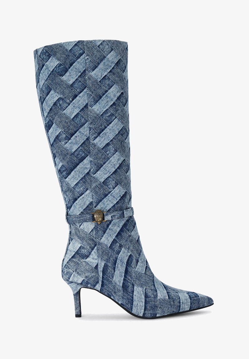 Botte de cheville à bout pointu en denim bleu avec texture tissée, présentant un petit talon et une boucle décorative en ton doré sur le côté.