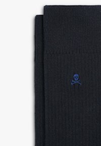 Marine sokken gemaakt van gebreide stof, met een klein blauw doodskop en -kruisbotten logo. Soepele textuur met geribbelde boorden voor een goede pasvorm.