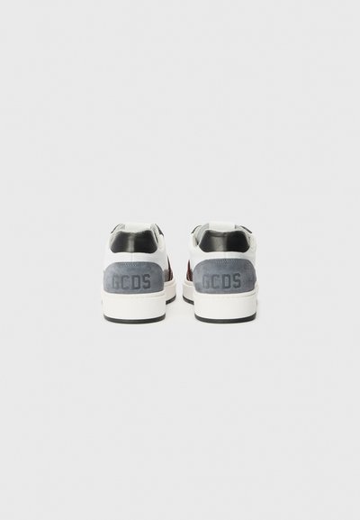 Sneaker bianche con accenti in suede grigi e neri, caratterizzate da un pannello posteriore testurizzato, logo "GCDS" in rilievo e tallone imbottito.