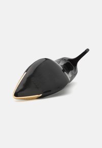 Scarpa con tacco alto nera a punta, con finitura lucida, caratterizzata da una texture a righe verticali e un accento metallic oro sulla punta.