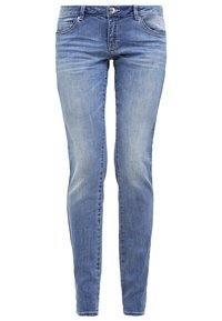 Jeans de mezclilla azul con corte ajustado, múltiples bolsillos, cierre de botón metálico y un leve desvanecimiento, con una textura suave.