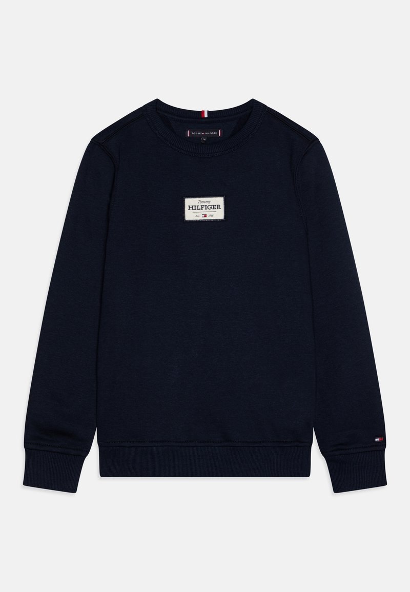 Felpa blu navy con scollo rotondo, tessuto strutturato, una toppa rettangolare bianca con la scritta "Tommy HILFIGER" e piccoli accenti con il logo sulle maniche.