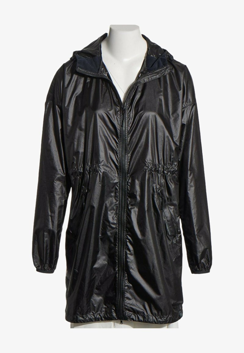 Long imperméable noir brillant avec fermeture éclair devant, poignets élastiques, poches latérales et capuche, présenté sur un buste de mannequin blanc.