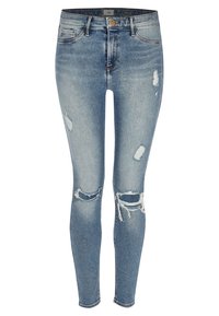 Jeans ajustados de mezclilla azul con detalles desgastados, que presentan desgarros en las rodillas, un talle medio y un lavado ligeramente descolorido.