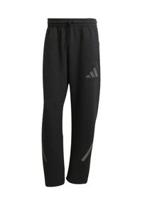 Čierne športové nohavice s elastickým pásom a šnúrkou na stiahnutie. Obsahujú reflexné prvky a zúžené nohavice pre moderný strih. Mäkká textúra látky.