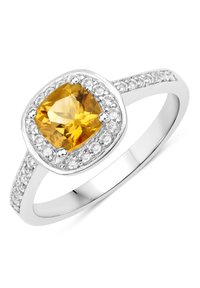 Kissenförmiger gelber Edelsteinring mit einem Silberband, umgeben von kleineren klaren Steinen in einem strukturierten Halo-Design.