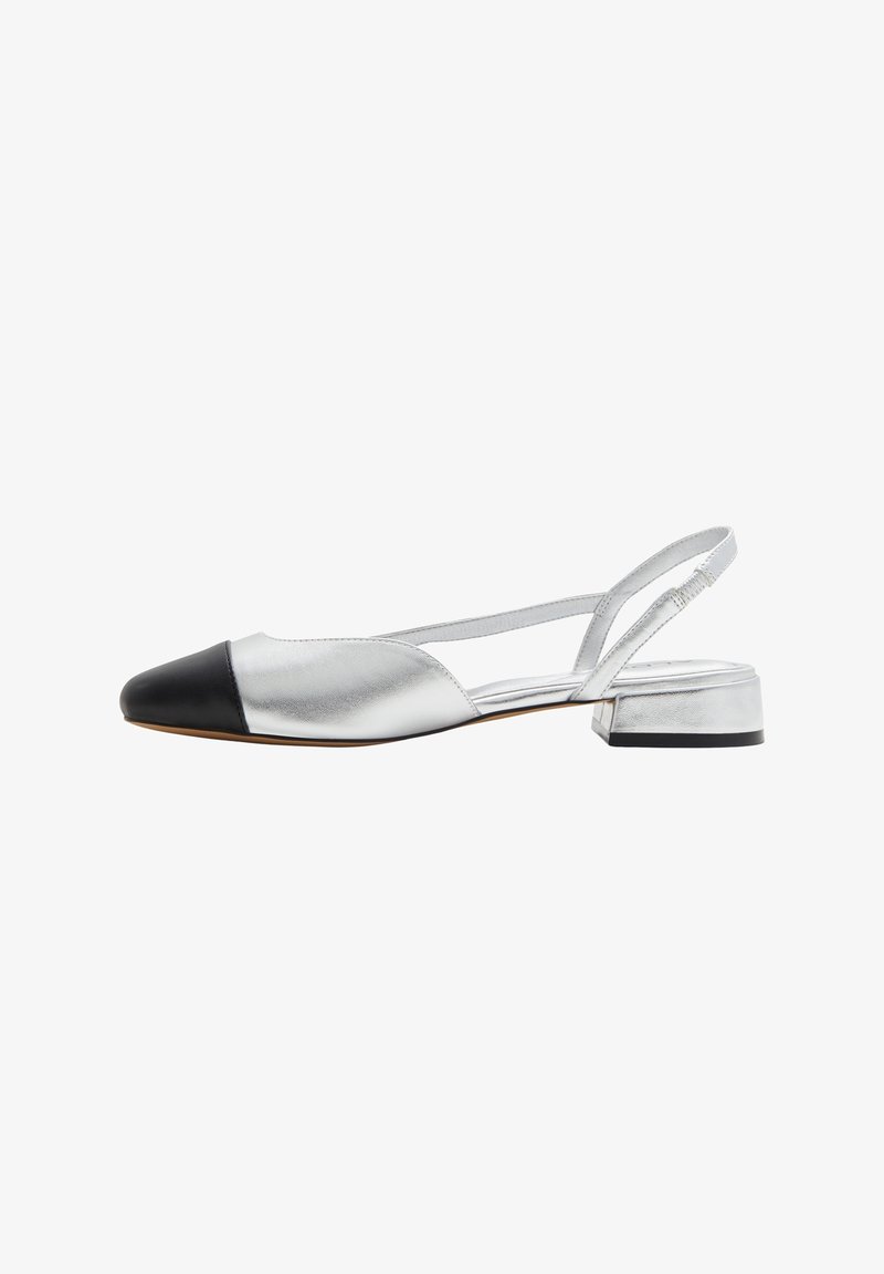 Zapato slingback plateado con acabado mate, punta redondeada y puntera negra. Presenta un tacón bajo y una correa delgada en el tobillo.