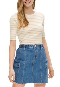 Gestreiftes creme- und gelbes, enganliegendes Oberteil; hochtaillierter blauer Jeansrock mit ausgefranstem Saum und vorderen Taschen; lässige, figurbetonte Silhouette.