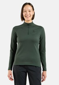 Dunkelgrünes, langärmeliges Sportshirt mit hohem Kragen, Halbreißverschluss und Logo auf der Brust. Glattes, feuchtigkeitsableitendes Material.