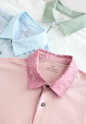 Kolm polo särki, millel on kontrastsed kraed: helesinine lilleline muster, roheline geomeetriline disain ja roosa lilleprindiga. Kangas on puuvillasegu.