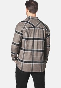 Braun und schwarz kariertes Flanellhemd mit button-down Kragen und langen Ärmeln. Verfügt über einen abgerundeten Saum und einen Rückenpasse-Detail.