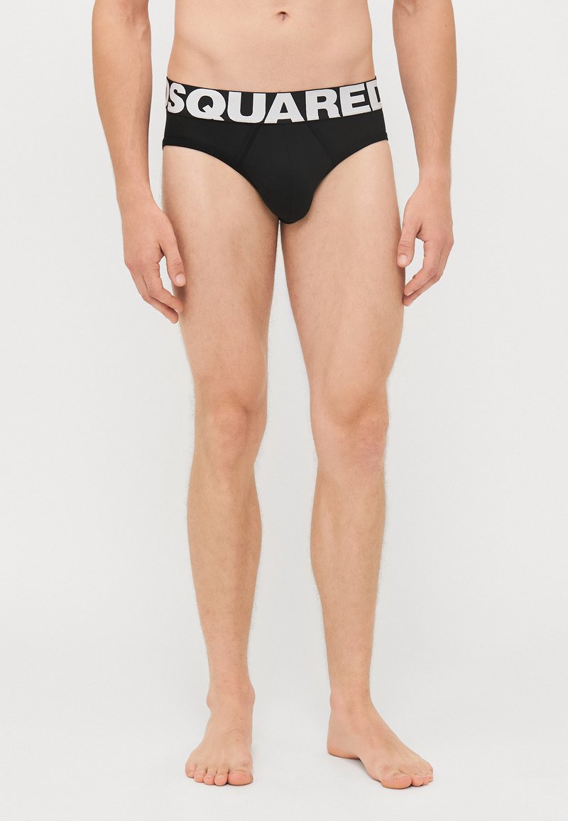 Schwarze Herrenunterhosen mit einem elastischen Bund, der das Logo "DSQUARED2" in Weiß trägt. Der Stoff ist glatt und das Design sitzt eng an.