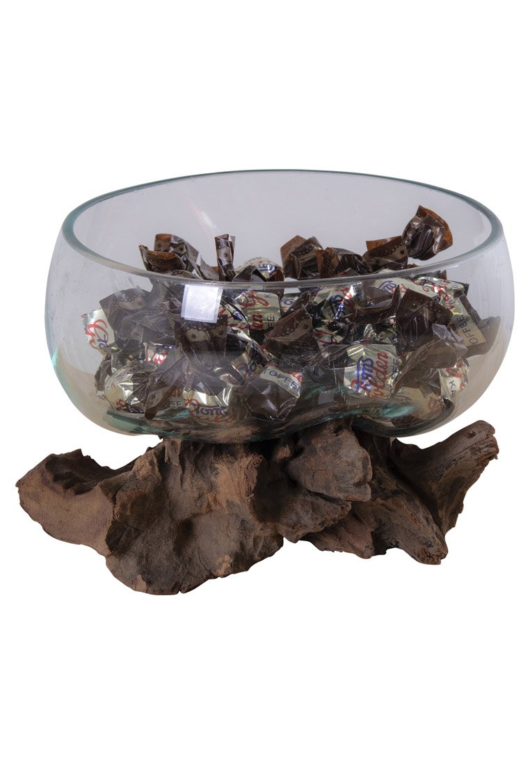 Bol en verre de forme arrondie sur une base en bois foncé texturé, rempli de chocolats emballés dans du papier métallisé brillant.
